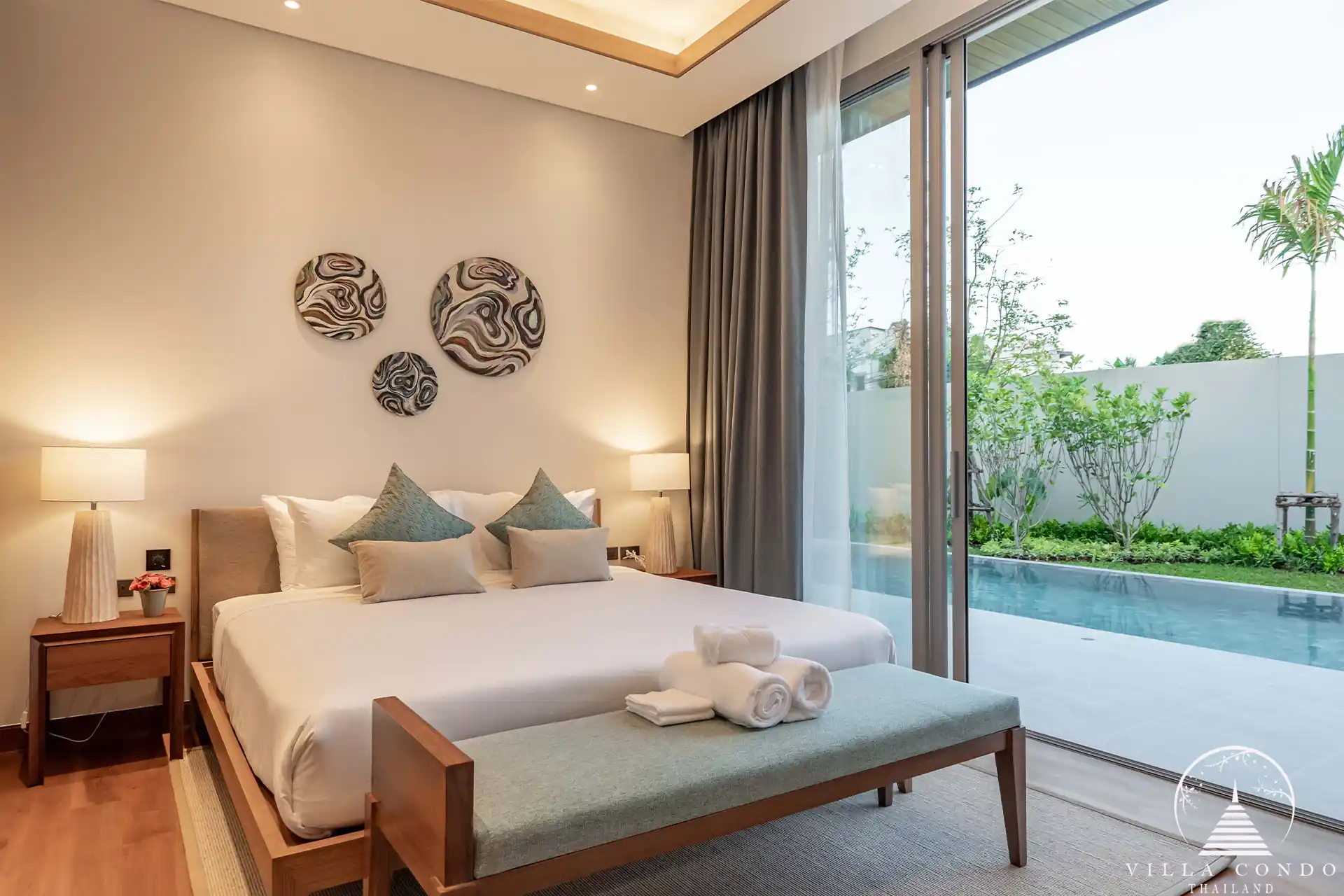 Spacious bedroom in Alinda Villas with large windows and stylish furniture.