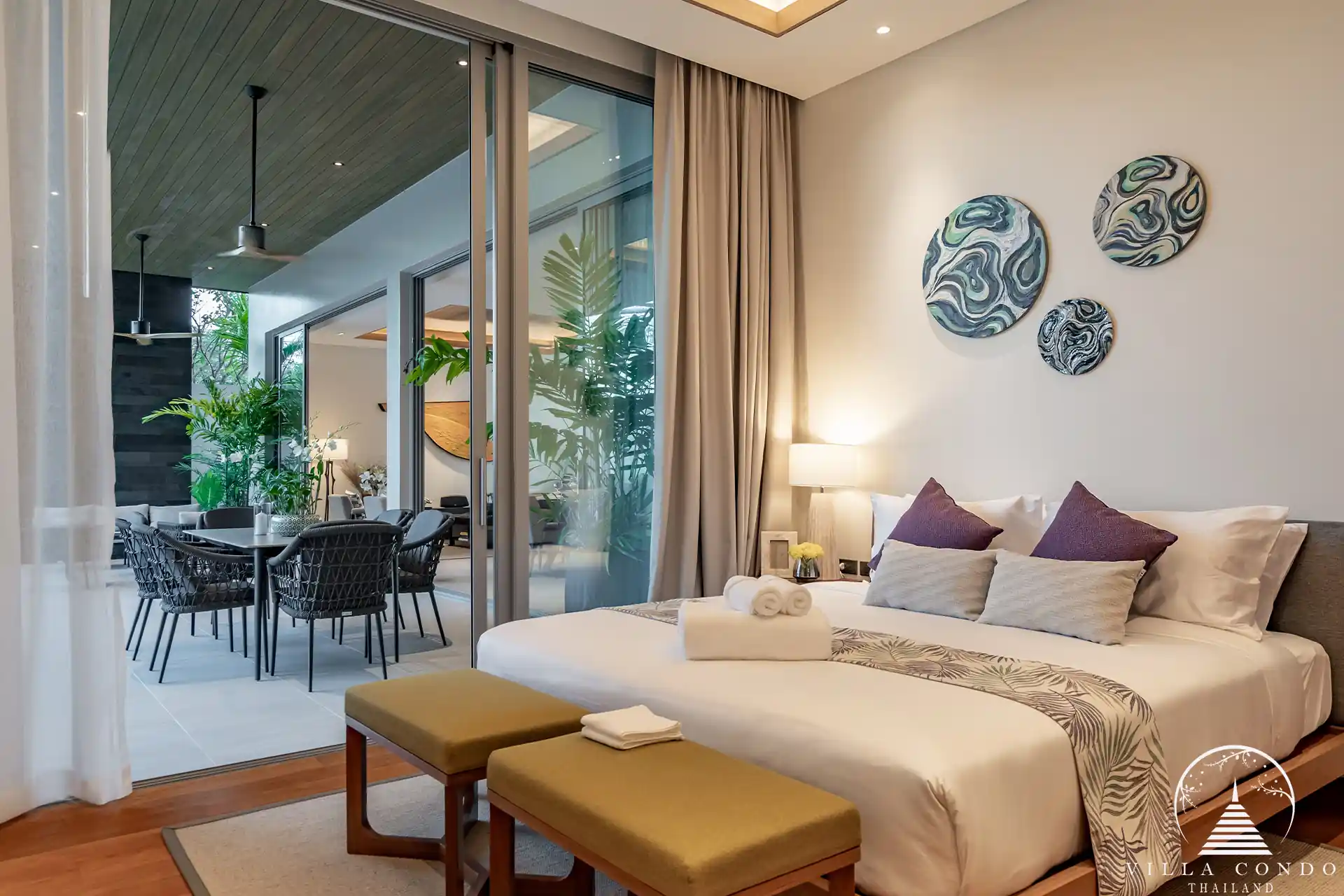 Spacious bedroom in Alinda Villas with large windows and stylish furniture.
