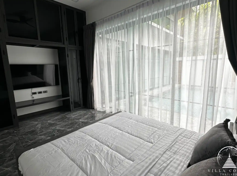 Spacious master bedroom with elegant decor and high ceilings.