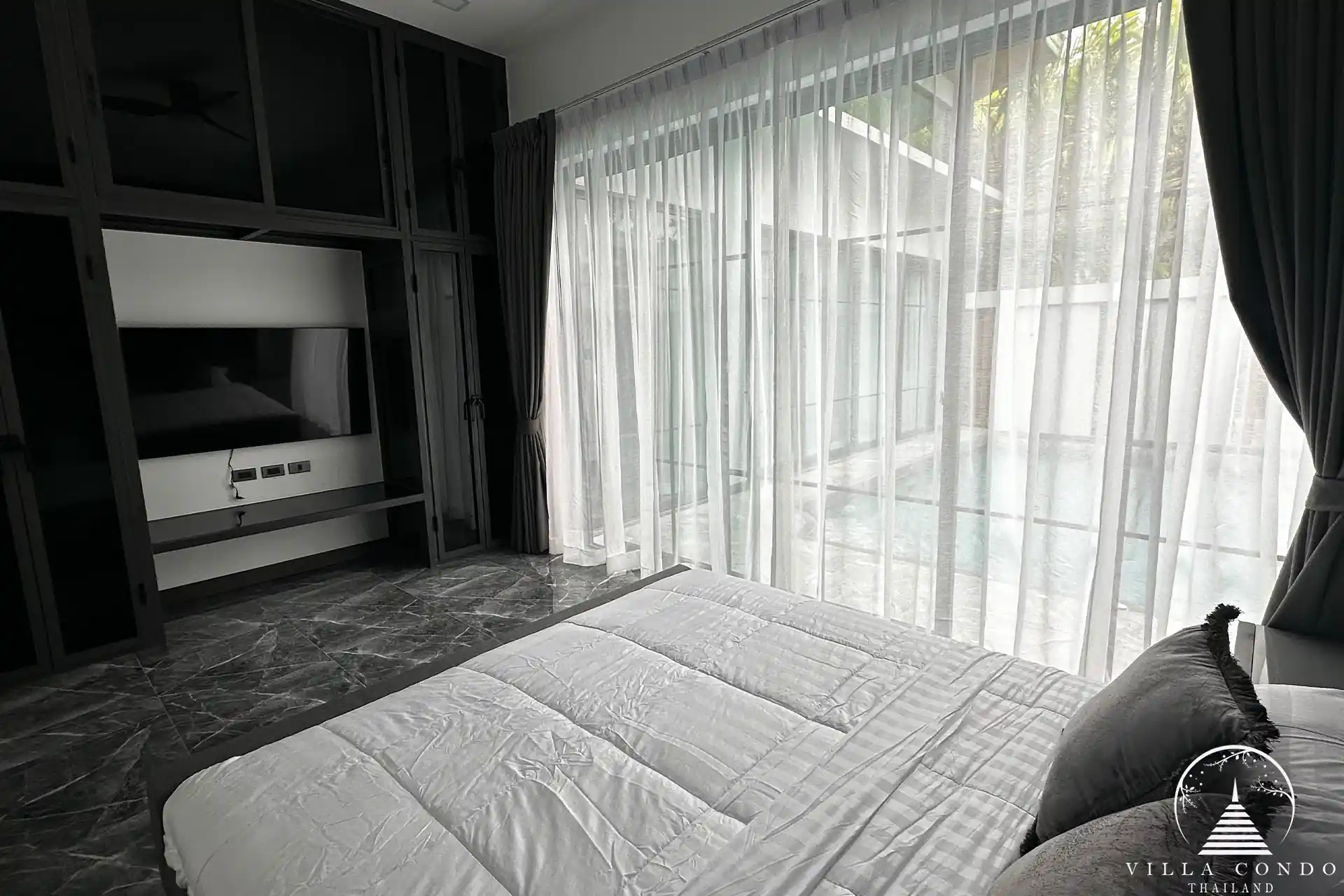 Spacious master bedroom with elegant decor and high ceilings.
