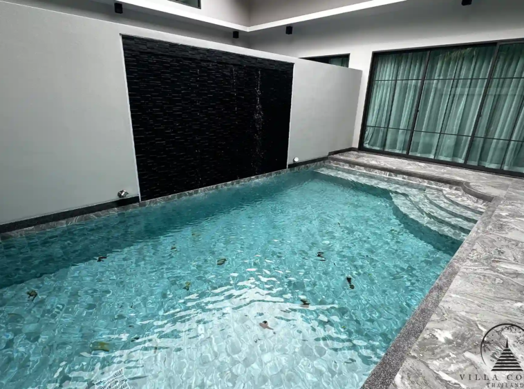 Private swimming pool with jacuzzi and waterfall feature.