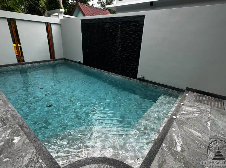 Private swimming pool with jacuzzi and waterfall feature.