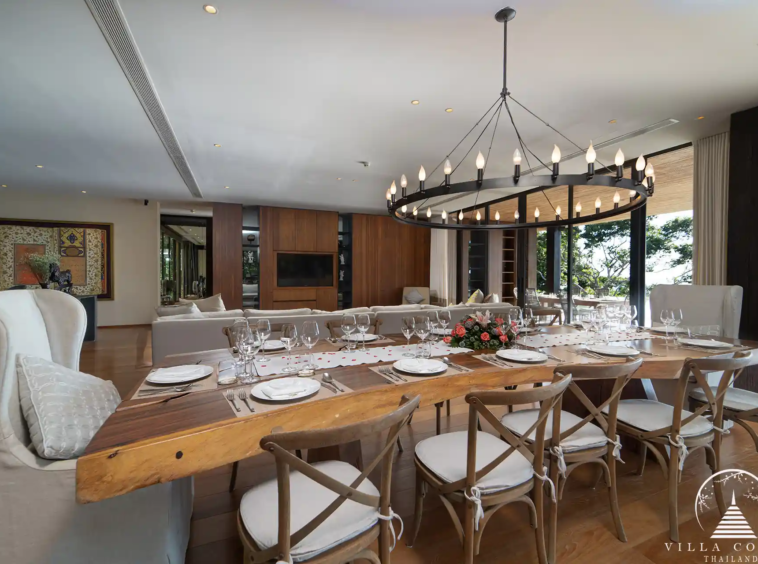 Spacious dining area in Villa Amarisa with a solid wood dining table and chic chandelier.