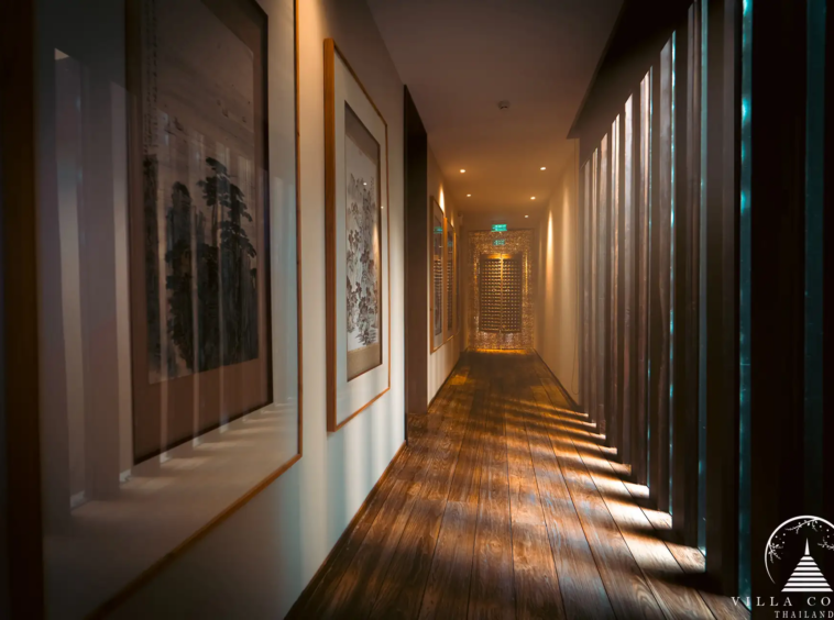 Villa Amarisa corridor with sandstone walls and polished teak hardwood floors.