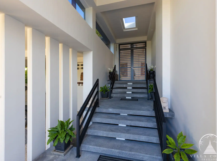 Elegant entrance of Villa Nova at Layan Hillside with natural stone and wood features.