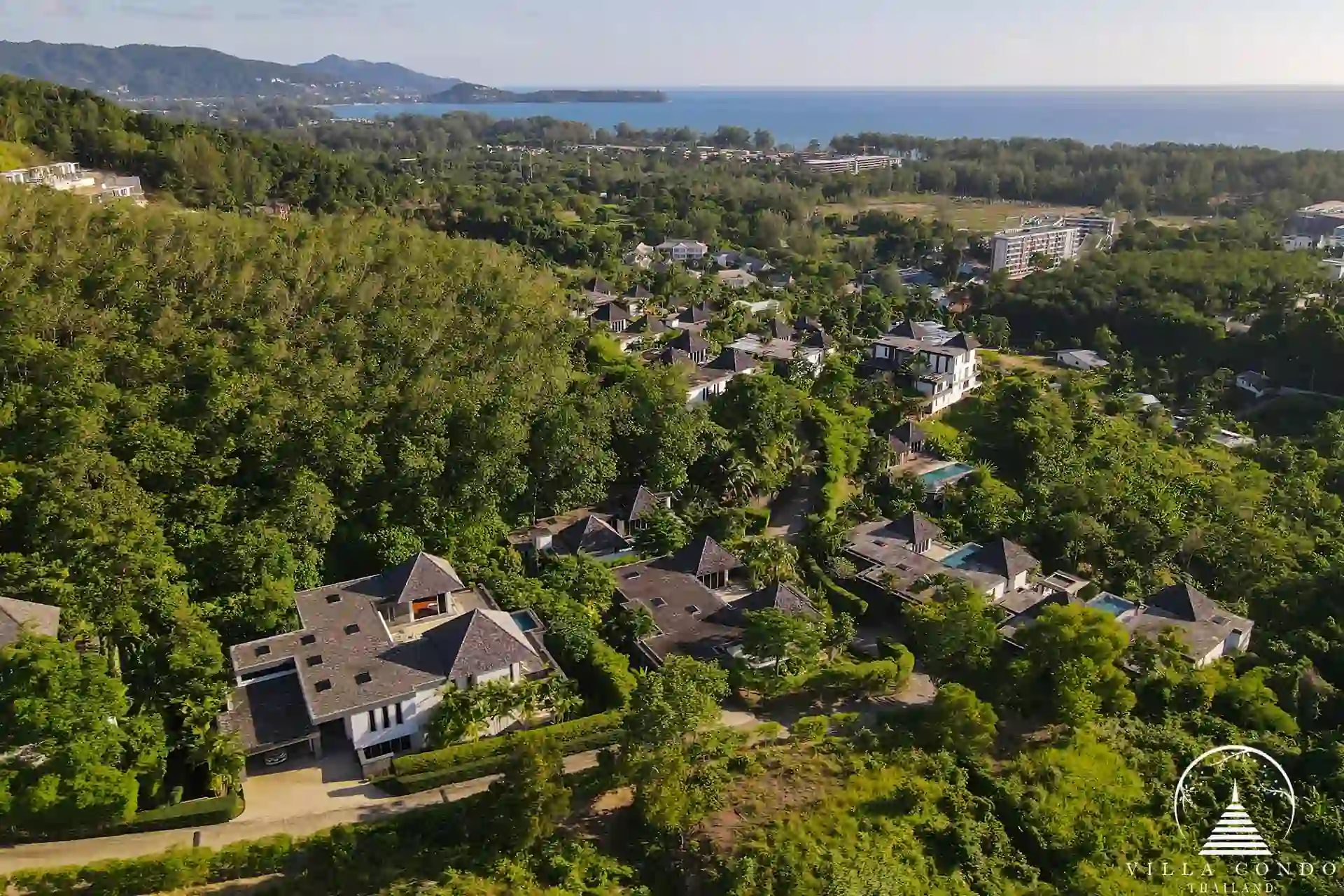 Bird’s eye view of Villa Nova at Layan Hillside and its surrounding lush landscape.