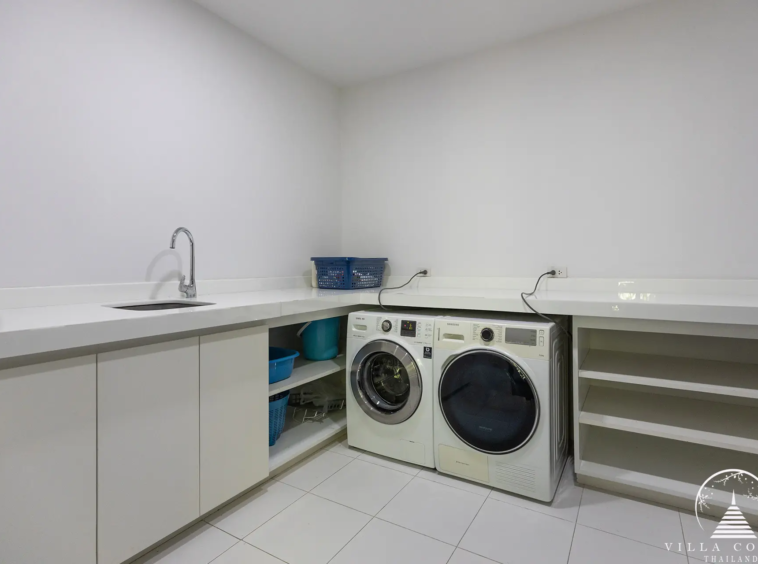 Functional laundry room at Villa Nova at Layan Hillside with modern appliances.