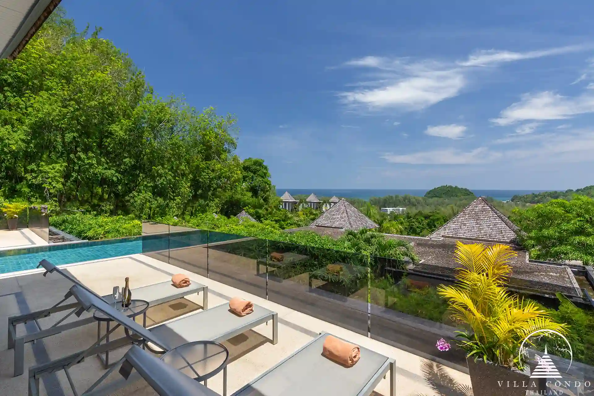 Sunbed area by the pool at Villa Nova at Layan Hillside with panoramic sea views.