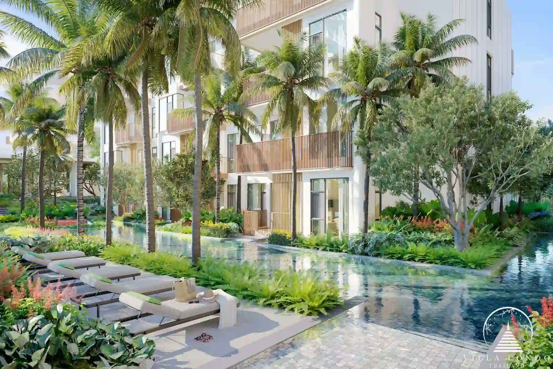 Common pool area with sunbeds at CANVAS Cherng Talay, surrounded by lush greenery.