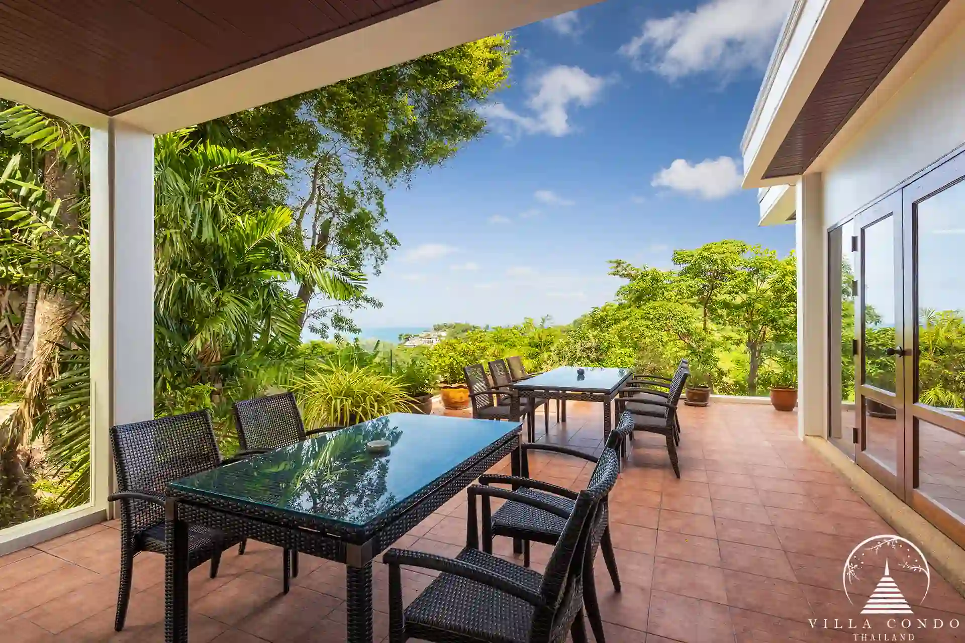 Outdoor dining area at Nakathani Villa Estate Kamala Beach surrounded by lush greenery.