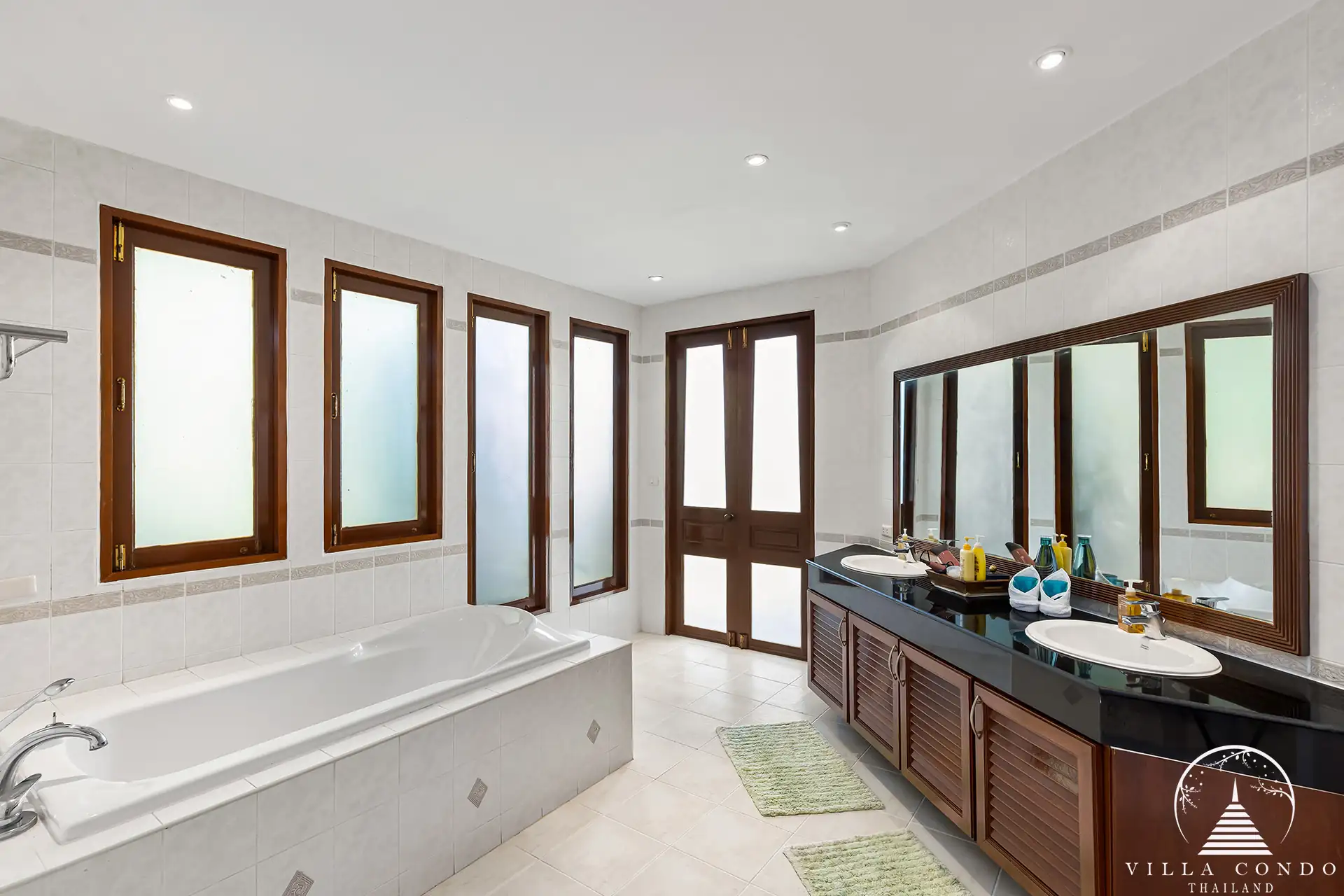 Spacious master bathroom with bathtub and garden views at Nakathani Villa Estate Kamala Beach.