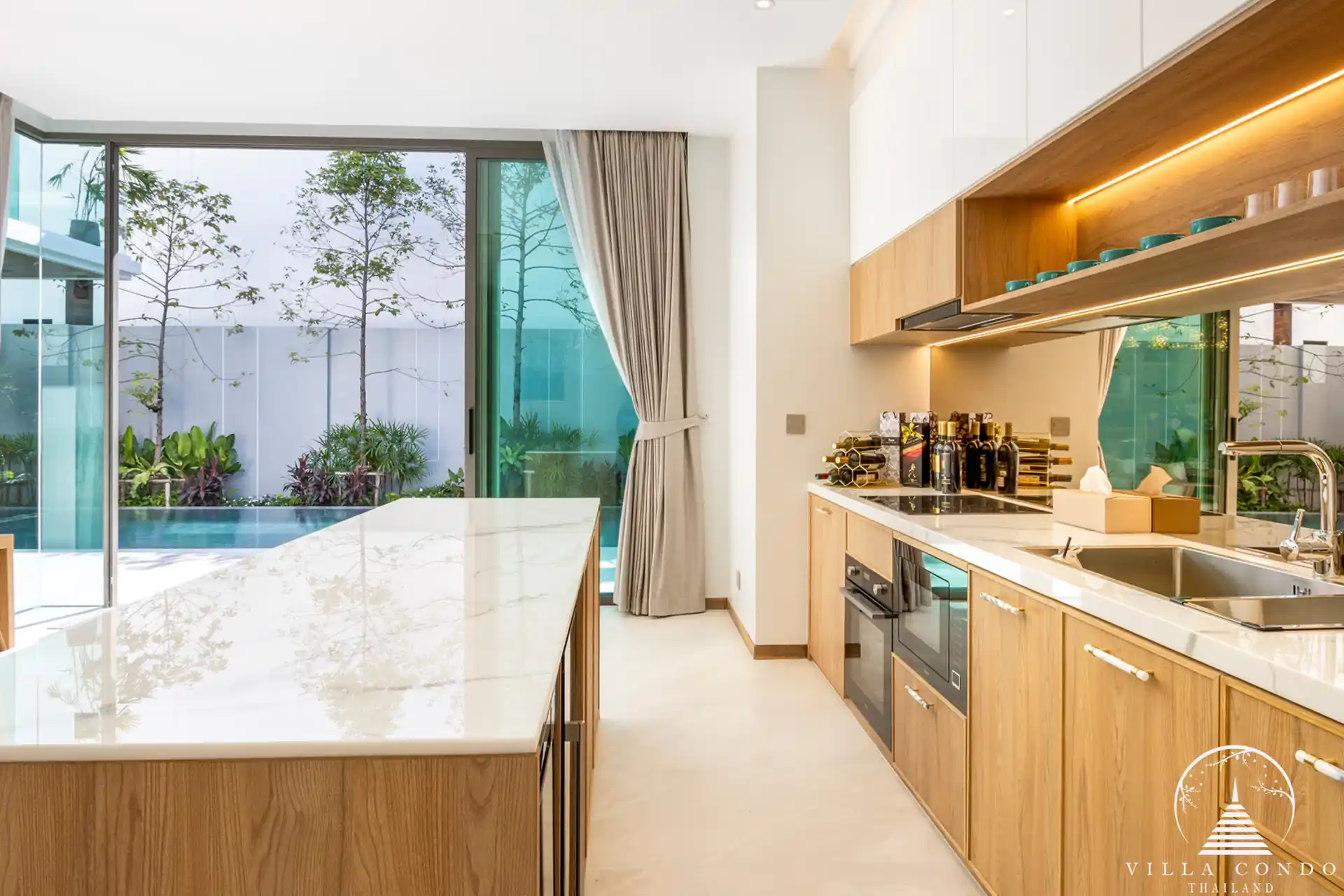 Modern kitchen with island and teakwood accents at The Teak Phuket