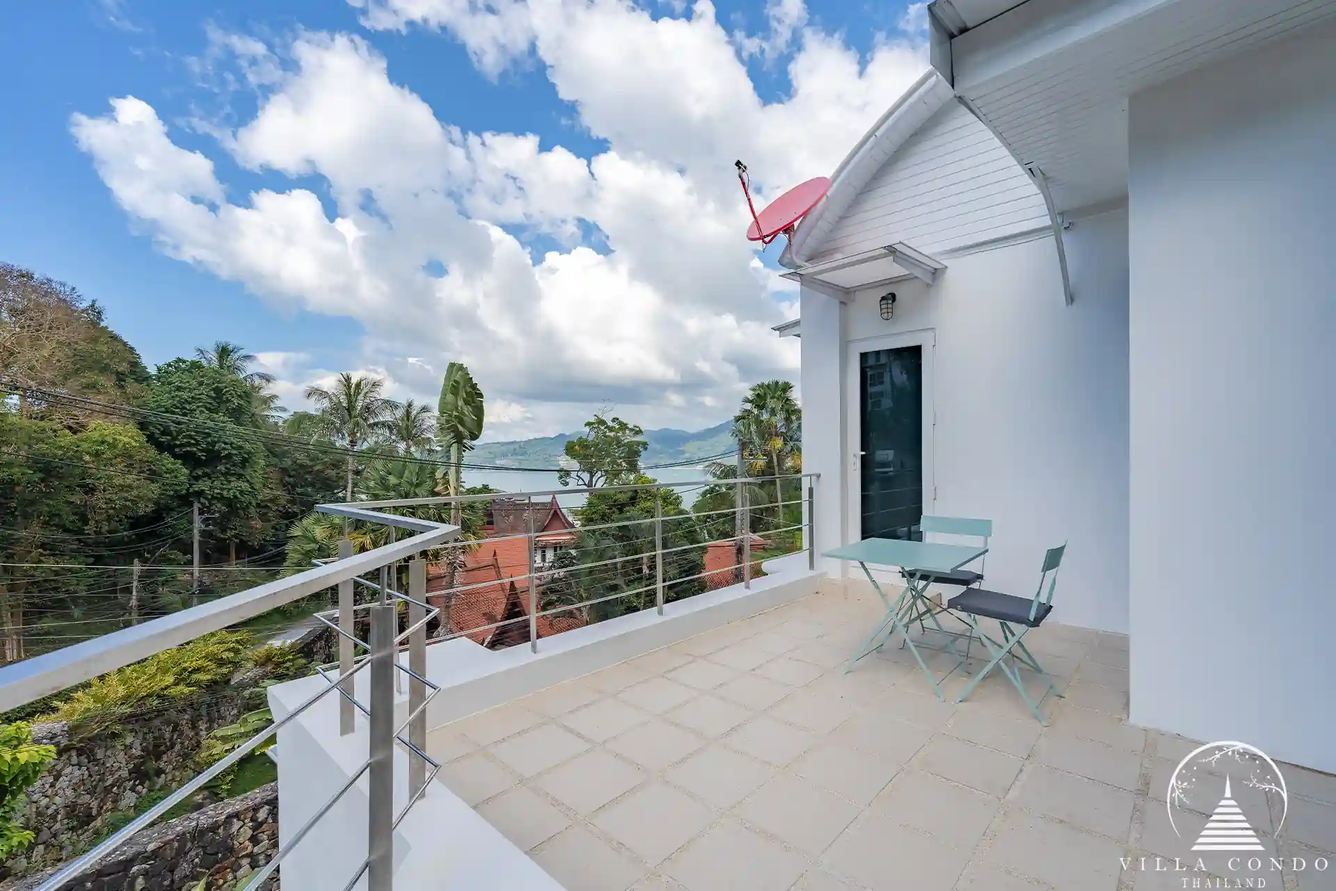 Balcony at White Villa Patong with views of the sea and mountains.