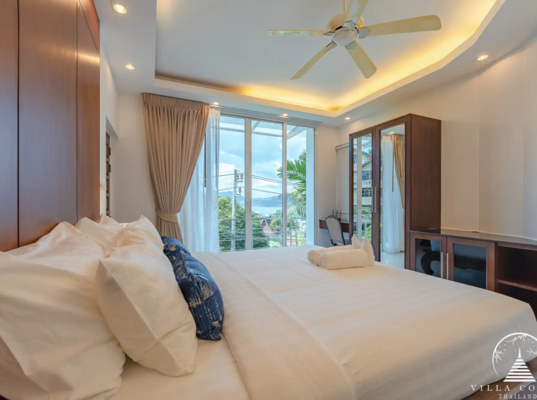 Guest bedroom in White Villa Patong with cozy décor and garden views.