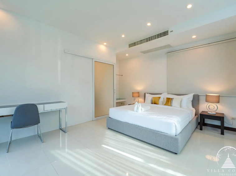 Spacious bedroom in White Villa Patong with balcony and sea view.