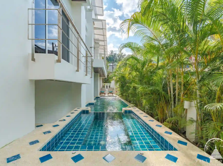 Outdoor area of White Villa Patong with pool and sea views.